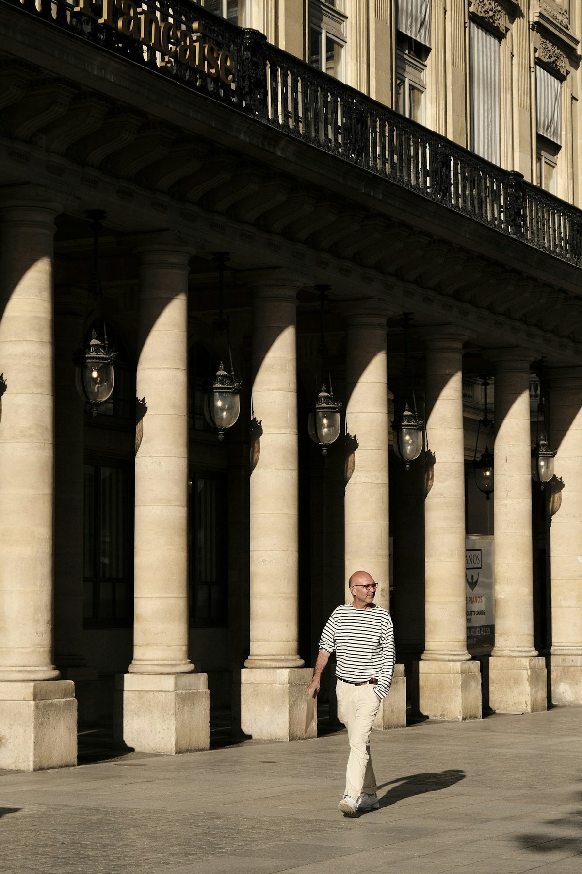 Man walking past Parisian columns
